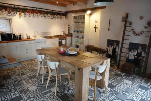 a kitchen with a wooden table and chairs at La Mosu in Porumbacu de Sus