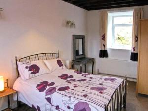 LlansannanにあるHendre Aled Cottage 2のベッドルーム1室(花柄のベッドカバー、窓付)