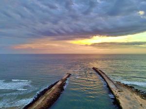 an old pipe in the ocean with a cloudy sky at Settler Sands - Holsboer Vacations in Port Alfred