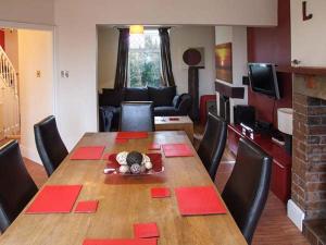 a living room with a wooden table with red napkins on it at 302 Over Lane Cottage in Belper