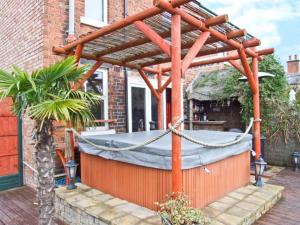a wooden pergola on a house with a hot tub at 302 Over Lane Cottage in Belper