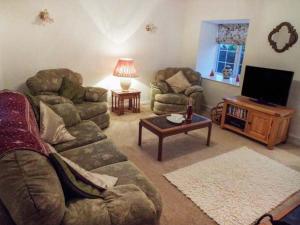 ein Wohnzimmer mit Couch und Flachbildfernseher in der Unterkunft Tyddyn Gyrfa Cottage in Cemaes Bay + 8 Fotos