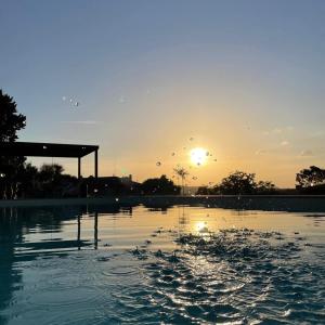 uma grande massa de água com o pôr-do-sol ao fundo em Villa Rina em Pesaro