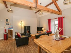 a living room with a table and a fireplace at Hen Blas in Aberdaron