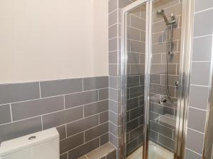 a bathroom with a shower with gray tiles at Hen Blas in Aberdaron