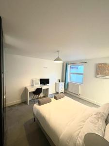een witte slaapkamer met een bed en een bureau bij Prosper House Apartment 5 in Norwich