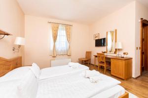 a hotel room with two beds and a desk and a table at Gastland M1 Hotel & Conference Center in Páty