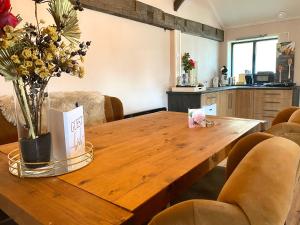 a wooden table with a vase of flowers on it at Vakantieverblijf Perron 3 in Haarle