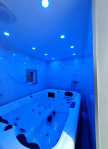 e bagno con vasca e illuminazione blu. di Spa de la Nacre, L'étape Repos a Andeville