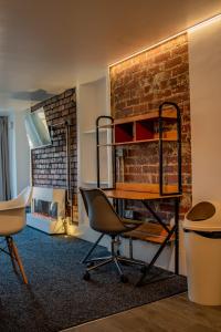 a room with a desk and chairs in front of a brick wall at BvApartments Dealhouse Nine in Huddersfield