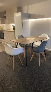 a table and chairs in a room with a kitchen at BvApartments Dealhouse Nine in Huddersfield