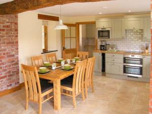 a kitchen with a wooden dining table and chairs at Tyn Y Celyn Canol in Clocaenog