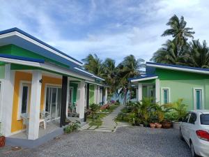 a house with a car parked in front of it at Coco Sea Bangpo Resort in Ban Bang Po