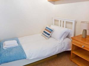 a white bed with two pillows and a night stand at Walker's Retreat in Ambleside