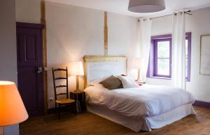 1 dormitorio con 1 cama blanca y 2 lámparas en Le Montellier, en Blacé