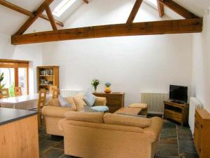 sala de estar con 2 sofás y TV en Riverside Barn en Gilwern