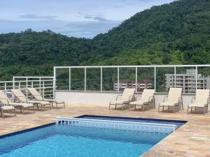 a deck with chairs and a swimming pool on a building at MORAMAR - PRAIA Das TONINHAS in Ubatuba