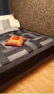 uma cama preta com uma almofada laranja em Riia 10, 2-bedroom apartment - 2 big beds 1 extra bed-parking free em Tartu