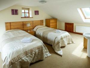 a bedroom with two beds and a sink at Parsley Cottage in Conder Green