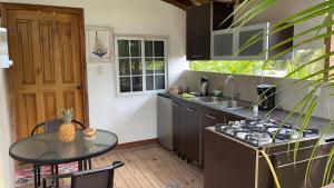 a kitchen with a table and a stove and a sink at El Arca de Pachue in Punta Chame