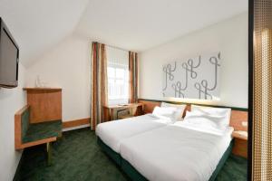a hotel room with a large bed and a large window at das seidl - Hotel & Tagung - München West in Puchheim