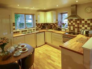 a kitchen with a table and a counter top at Bridleway Cottage in Wennington