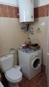 a bathroom with a toilet and a washing machine at Sweet Home in Volos +9 photos