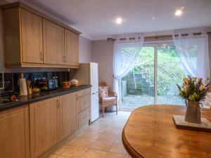 a kitchen with a wooden table and a large window at Teifi House in Cilgerran