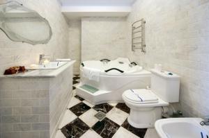 a bathroom with a toilet and a tub and a sink at Boutique Hotel California in Odesa