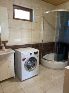 a bathroom with a washing machine and a shower at Villa OCTOPUS in Dąbki