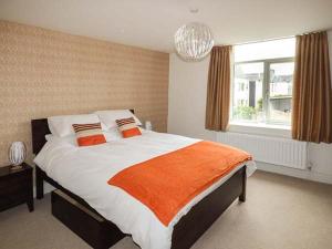 a bedroom with a large bed with an orange blanket at Crooklands House 2 in Crooklands