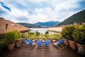 a group of chairs sitting on a patio with a view at Bello!Lake Como Suites in Como