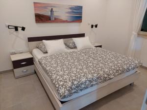 um quarto com uma cama e um farol na parede em Apartment Sky View em Cres