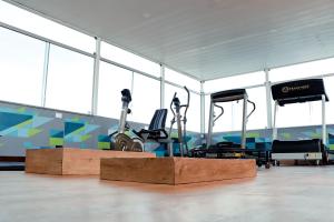 un gimnasio con equipo cardiovascular en una habitación con ventanas en San Marino Hotel, en Paulo Afonso