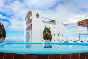 a building with a pool in front of a building at San Marino Hotel in Paulo Afonso