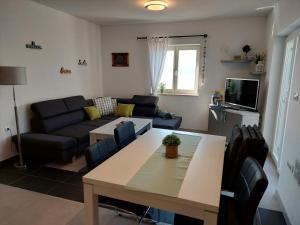 uma sala de estar com um sofá e uma mesa em Apartment Sky View em Cres