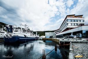 dwie łodzie zacumowane w przystani obok budynku w obiekcie Thon Hotel Fosnavåg w mieście Fosnavåg