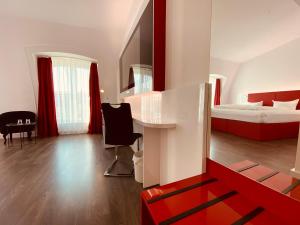 a bedroom with a bed and a desk in a room at DORMERO Hotel Dresden City in Dresden