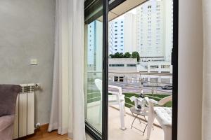 Zimmer mit einem Balkon mit Tisch und Stühlen in der Unterkunft Columbano Garden, Family Apartment in Lissabon