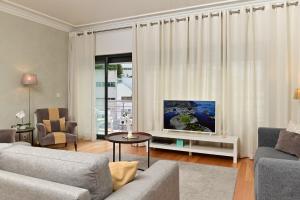 a living room with a couch and a tv at Columbano Garden, Family Apartment in Lisbon