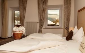 a bedroom with two white beds and a window at Hotel Martinerhof in San Lorenzo di Sebato