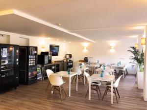a restaurant with white tables and white chairs at Hotel K1 Nohra - bei Weimar in Nohra
