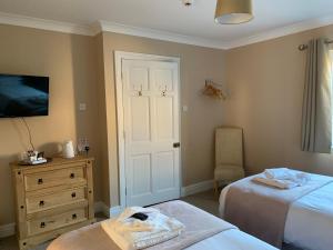 a bedroom with two beds and a dresser and a door at Lakeside Lodge Golf and Country Club in Huntingdon