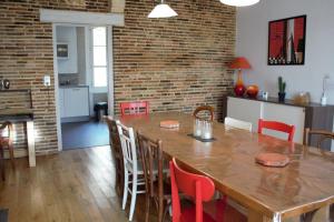 una cucina e una sala da pranzo con tavolo e sedie in legno di Gîtes Famille En Othe a Bouilly