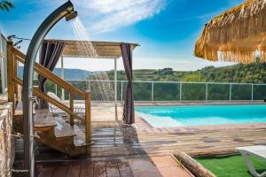 uma vista para uma piscina a partir de uma casa com uma rede de descanso em les vignes Ardéchoises - Peuplier em Sarras