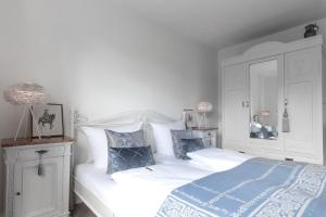 1 dormitorio con cama blanca y almohadas azules en BALTHAZAR, das kleine Hotel Iphofen, en Iphofen