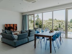 ein Wohnzimmer mit einem Tisch und Stühlen in der Unterkunft Blue Rela Luxe Resort Okinawa in Onna