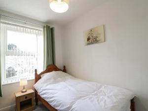 1 dormitorio con cama y ventana en 1 Rubby Banks Road en Cockermouth