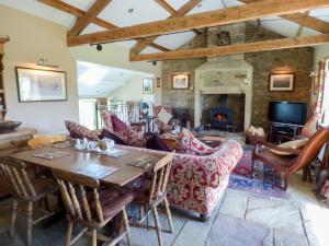 a living room with a table and a fireplace at Humbleton Cottage in Langley