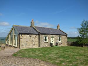 an old stone house with a large yard at Humbleton Cottage in Langley
